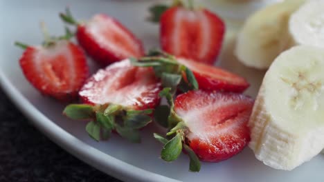fresas cortadas y plátanos en un plato