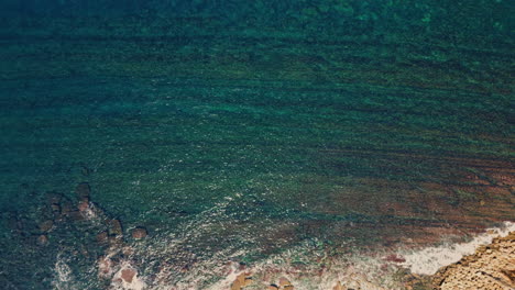 turquoise sea waves rippling under summer sunlight aerial view. clear blue ocean