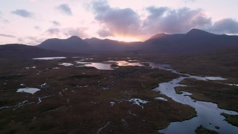 Imágenes-De-Drones-De-Un-Paisaje-De-Humedales-De-Islas-Y-Turberas-Rodeadas-De-Agua-Dulce-Mirando-Hacia-Las-Montañas-En-El-Horizonte-Al-Atardecer