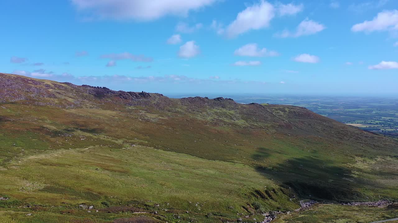 vista aérea de la órbita de la cordillera que pasa sobre un río y una carretera en el sur de irlanda en verano