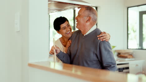 Laughing,-hug-and-a-senior-couple-cooking