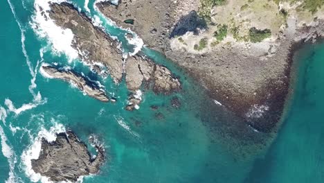 aerial shot, drone view looking above panning, waves hitting the rocks medlands beach, great barrier island, new zealand