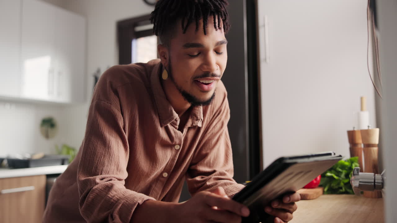 Young Man Using Tablet in Kitchen