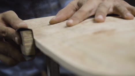 Craftsman-sanding-skateboard-to-make-it-smooth-as-silk,-close-up-view