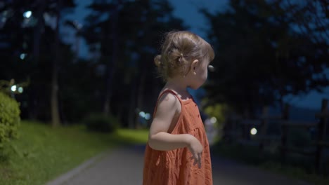 retrato de un niño caucásico de 2 años en el parque por la noche