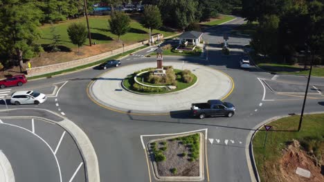 backwards aerial of roundabout with heavy traffic in