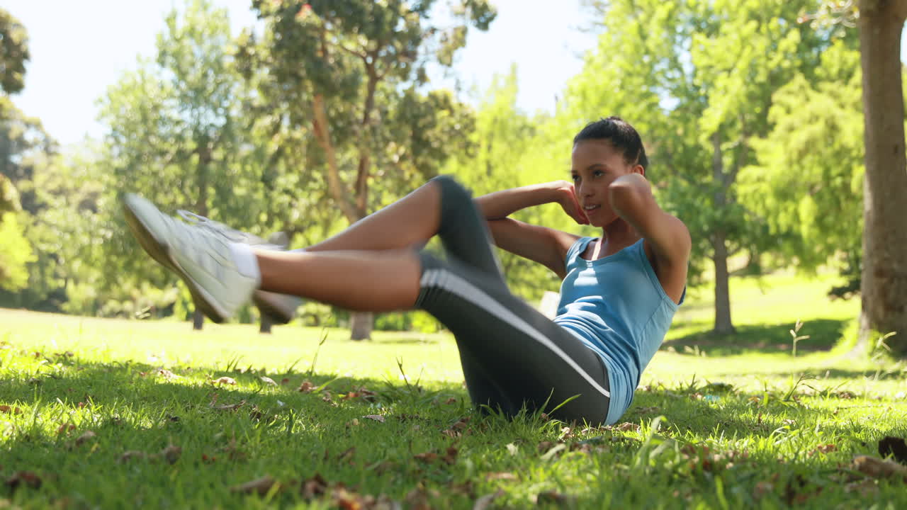 mujer en forma haciendo abdominales en el parque
