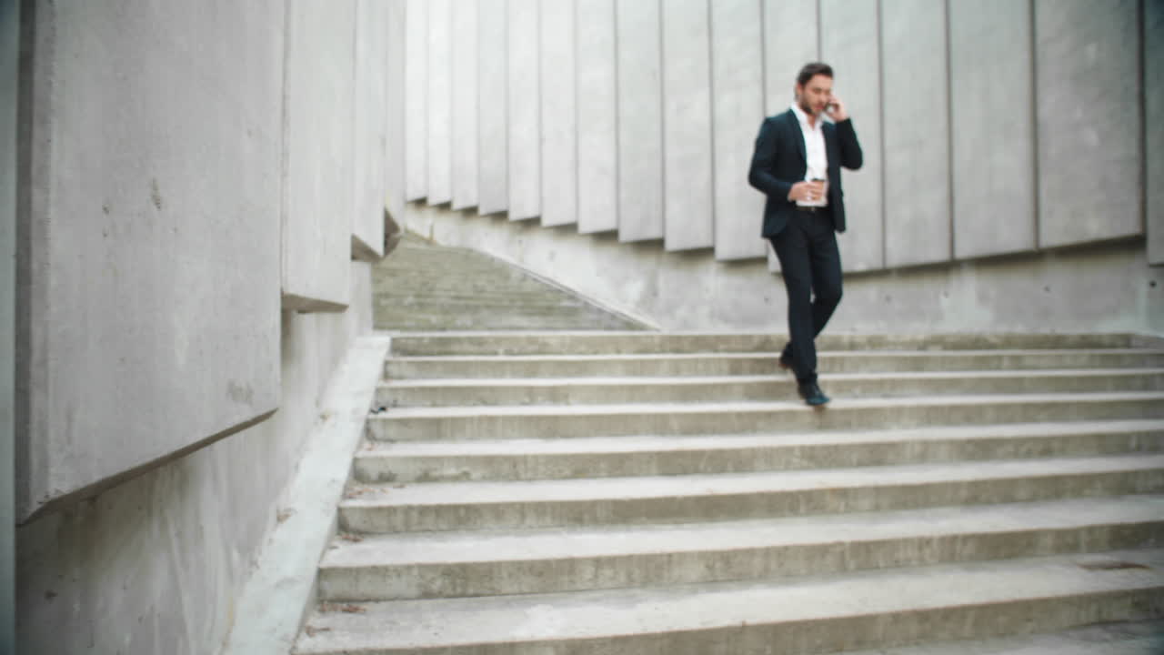 길거리에서 일하러 달리는 사업가. 스마트폰으로 전화하는 남성 사업가
