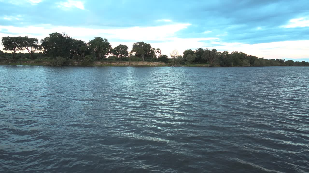 disparo constante en un barco de safari en movimiento en una gira de zambia con un bonito reflejo y algunas nubes