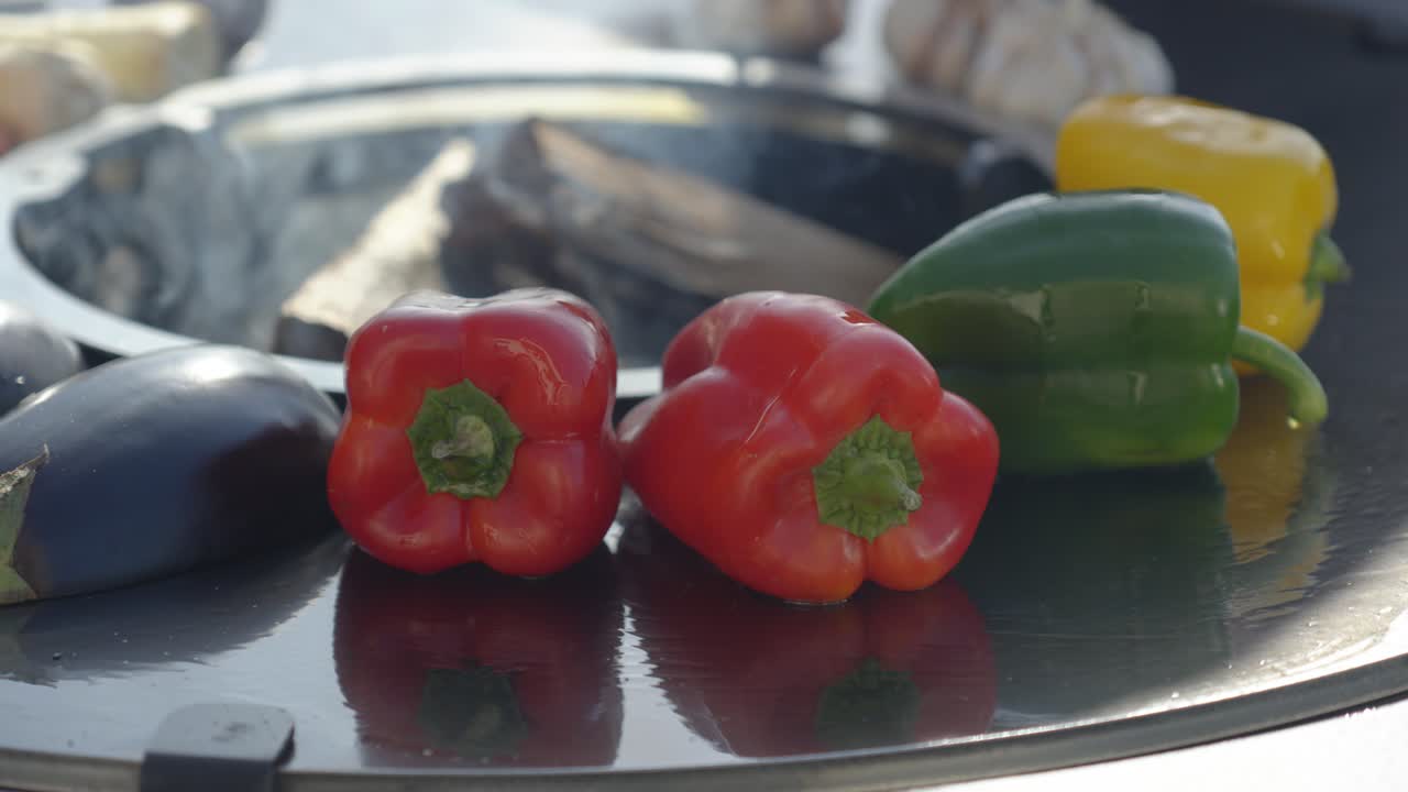 yellow, green and red peppers roasting on an open top bbq