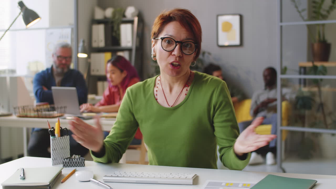 Mid-Age Businesswoman Talking on Camera on Web Call in Office