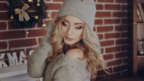 Woman portrait in Christmas room. Young pretty woman with fashion hair and makeup posing at Christmas interior