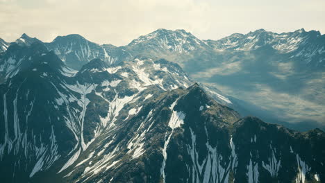 aerial over valley with snow capped mountains in distance