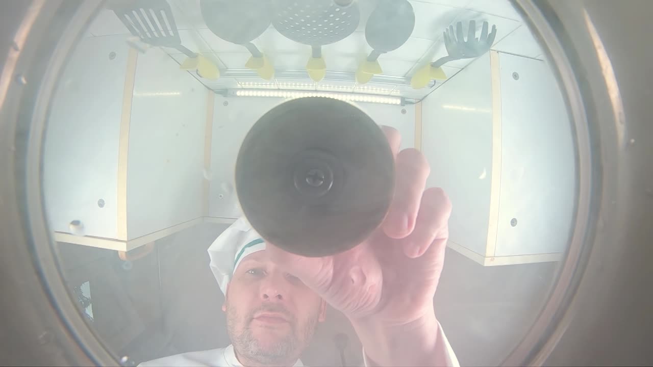 el chef prepara caldo de verduras, el chef añade especias a la sopa, la vista desde la sartén en cámara lenta.