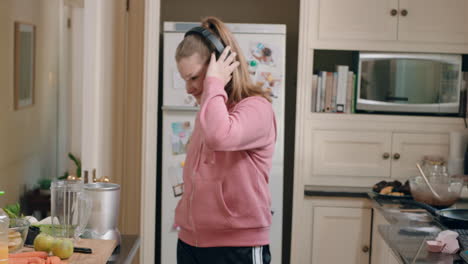 happy-teenage-girl-dancing-in-kitchen-having-fun-celebrating-weekend-performing-funny-dance-moves-listening-to-music-wearing-headphones