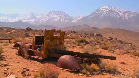 Abandoned-pickup-truck-with-the-snowcapped-Sierra-Nevada-mountains-with-the-sun-shining-through-clouds-1