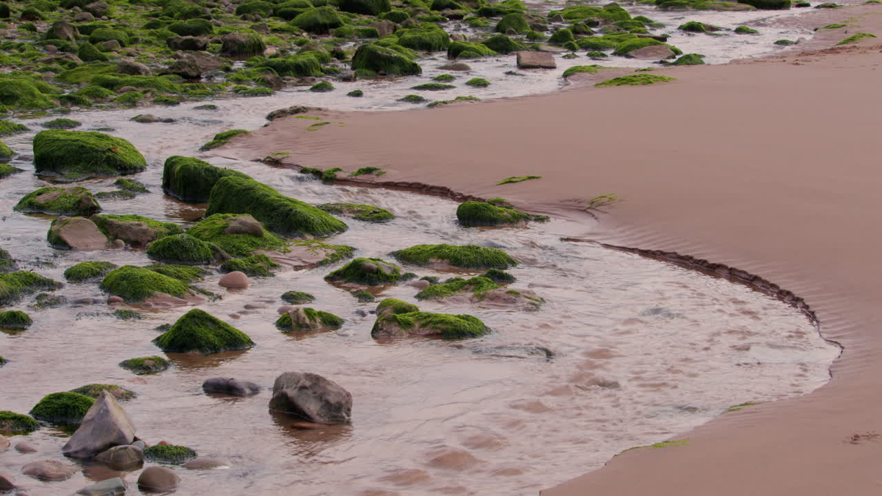 로팅턴 에서 바다로 흘러 들어오는 물의 넓은, 웨스트 레이크 디스트릭트 (west lake district) 의 세인트 비스 (saint bees) 해변에서 물결이 낮을 때.