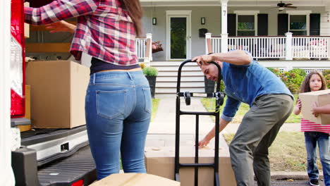 Children-Helping-Unload-Boxes-From-Van-On-Family-Moving-In-Day