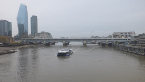 merchant ship sailing along thames river, london