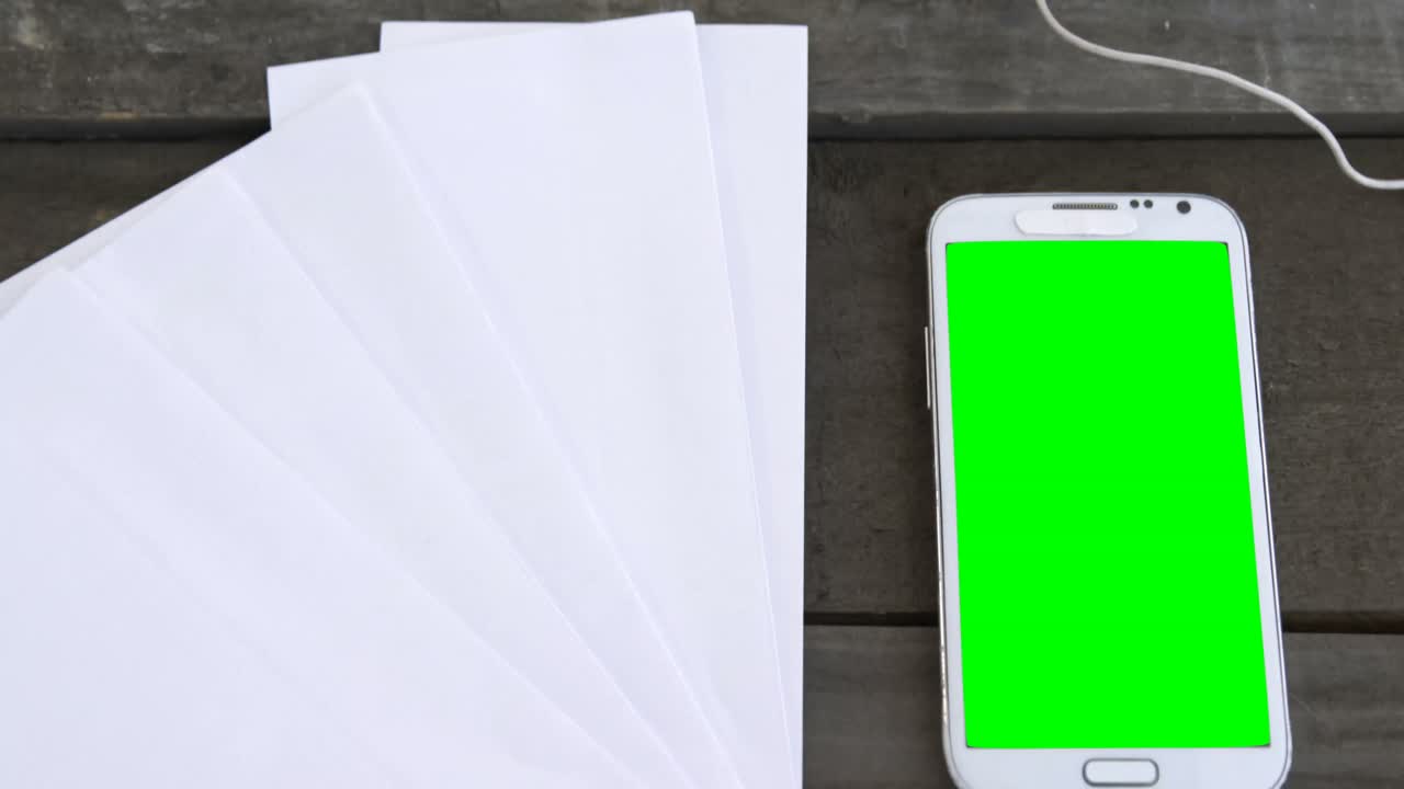 Fogli bianchi, cellulare, cuffie e tablet su tavolo 4k