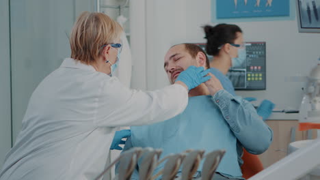 senior dentist examining patient with serious toothache