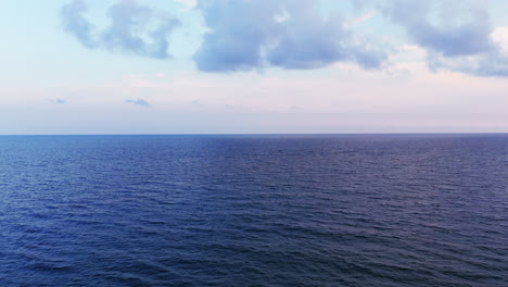 endless view of the calm mediterranean sea under a soft blue sky in liguria, italy