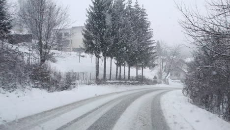 Conducir-En-El-Bosque-Por-Una-Carretera-Con-Curvas-Con-Fuertes-Nevadas