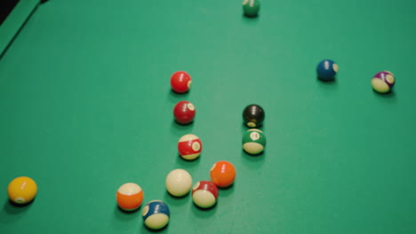 billiard balls explode from triangular formation on green pool table after powerful break shot, rolling in multiple directions with forceful impact, creating dynamic motion and fast-paced action