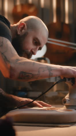 guitar maker working on instruments in workshop