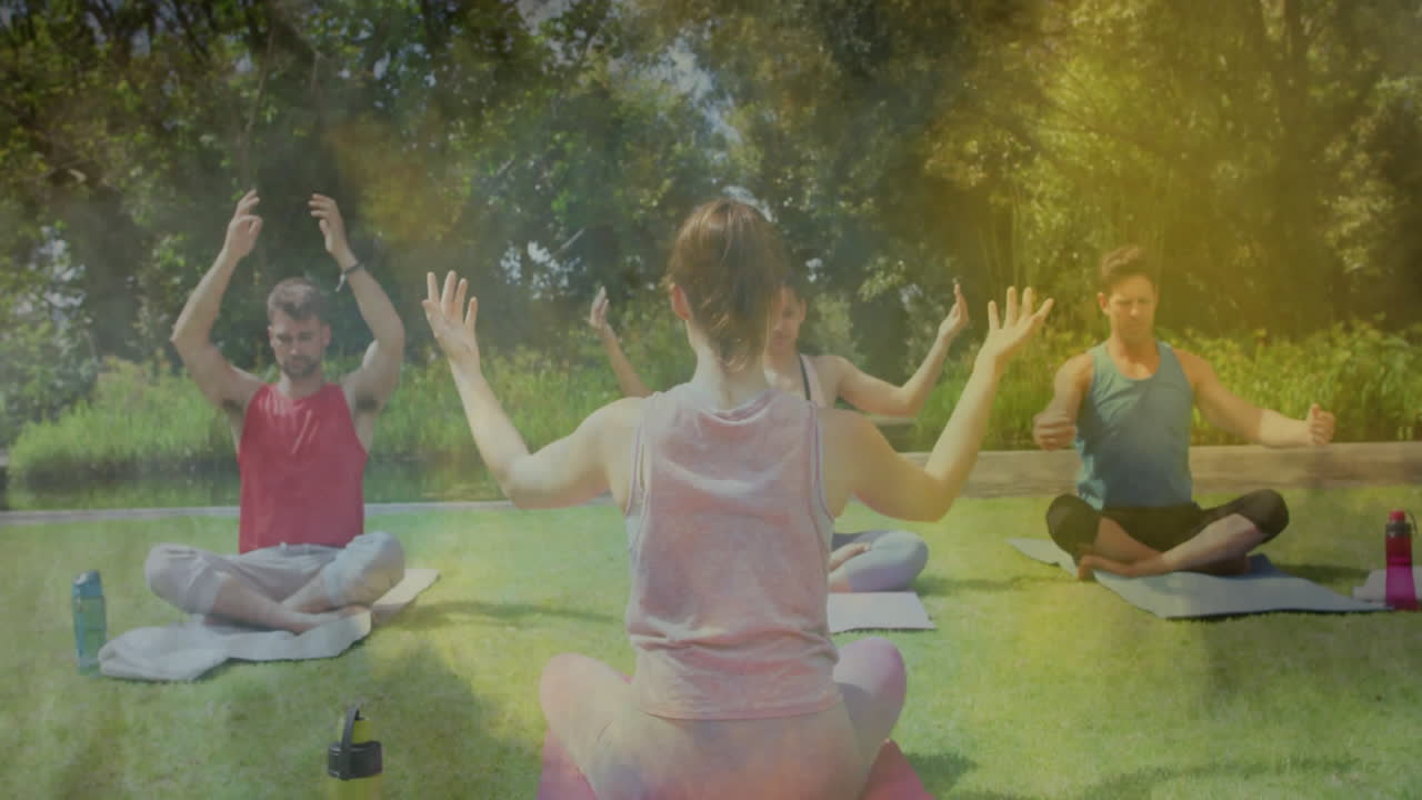 Group practicing outdoor yoga on mats, showing floating health chart and heart icon animations
