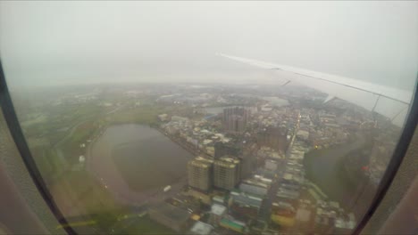 aterrizando en el aeropuerto internacional de taiwán taoyuan en un día de invierno nublado y lluvioso volando sobre edificios