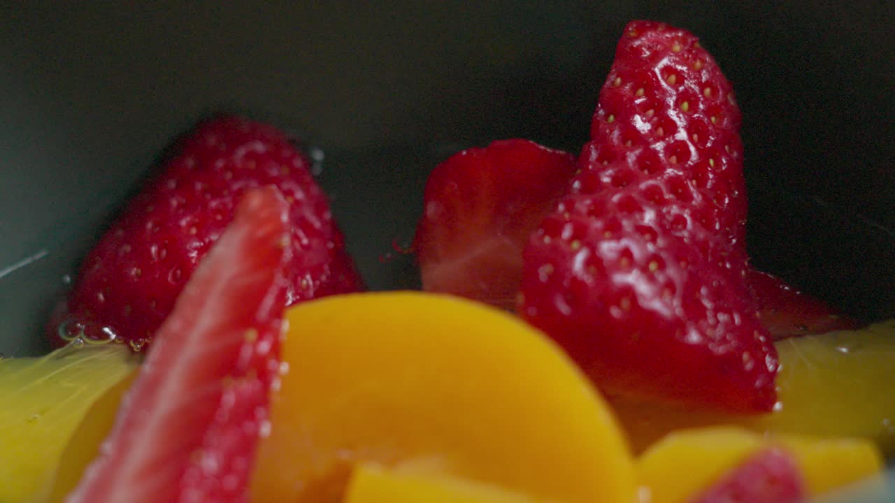 Strawberries Falling and Bouncing in Bowl in Slow Motion with Peaches for Fresh Summer Dessert