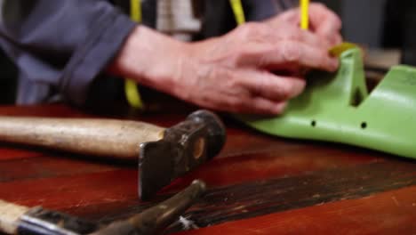 shoemaker marking on shoe last with pen