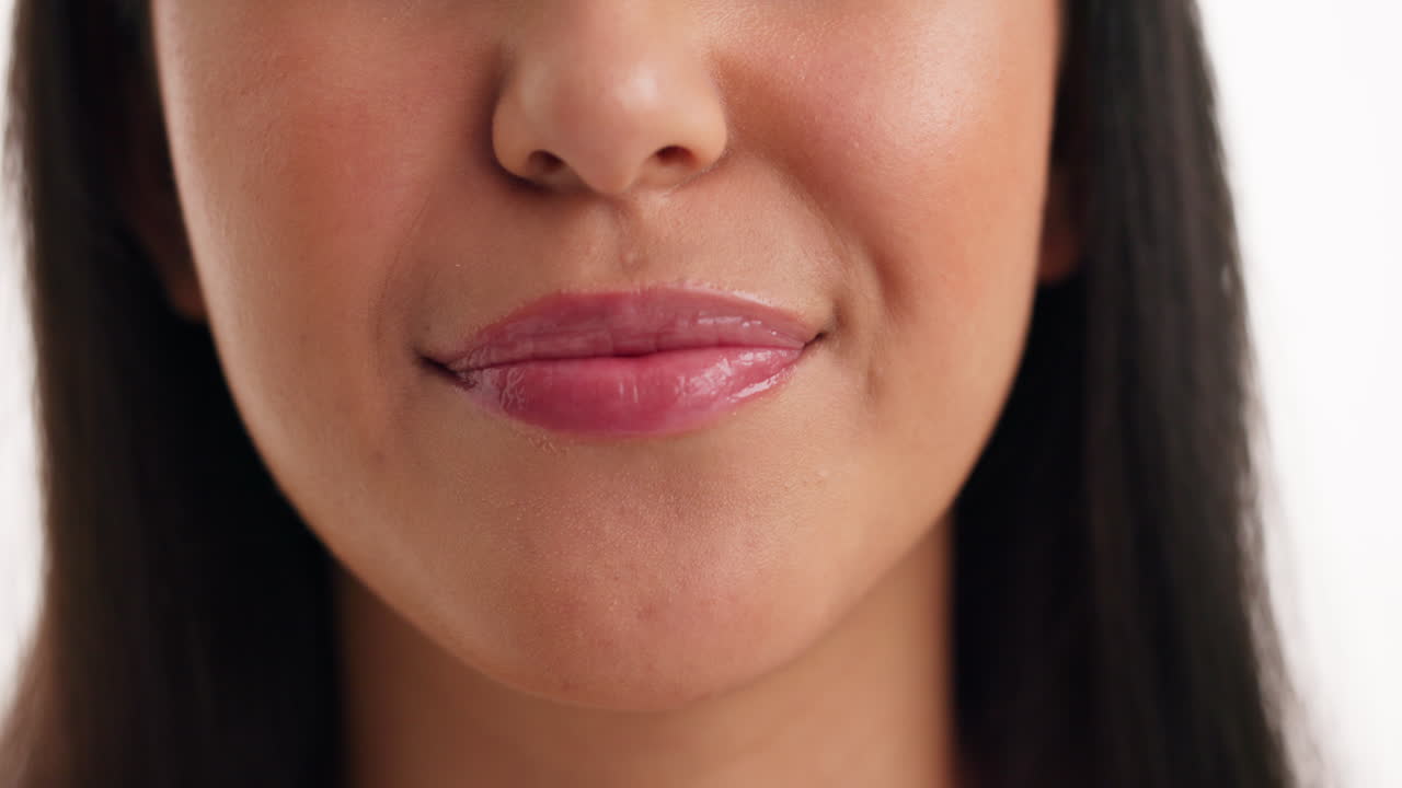 Close-up of a woman's face showing her finger pulling her lip to show her teeth