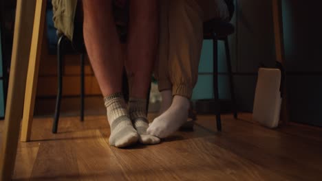 shooting up close: a view of the legs of a girl and a guy who touch each other in socks