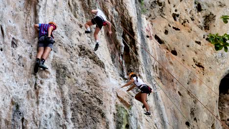 two climbers scaling a steep rock face