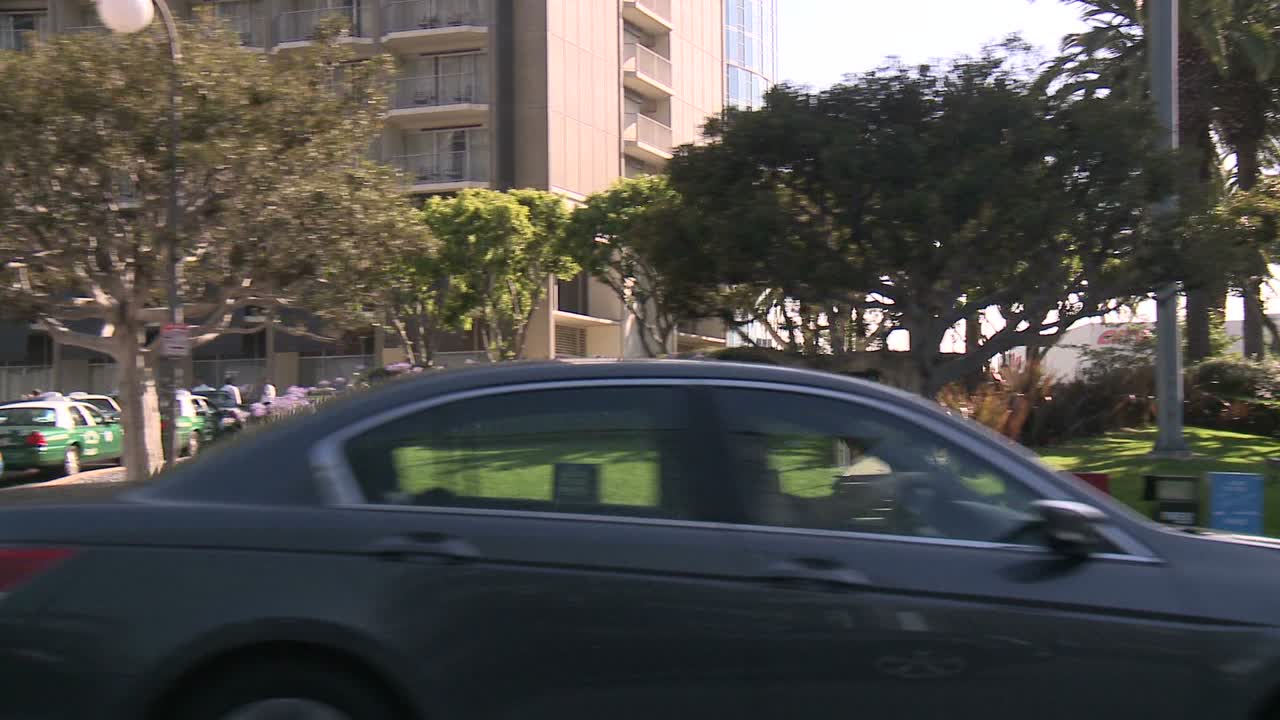 un automóvil viaja a lo largo de la avenida de las estrellas en la ciudad del siglo de los ángeles como se ve a través de la ventana lateral 2