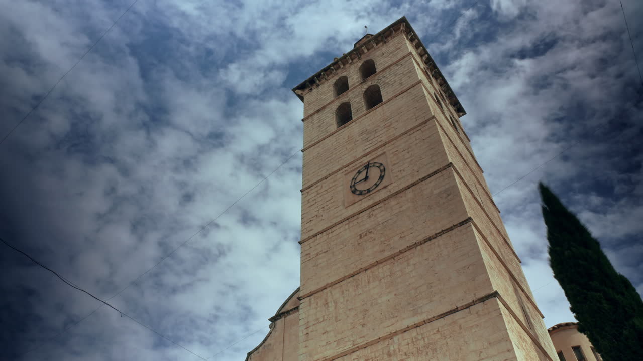 Questo timelapse cattura l'antica torre della chiesa di Inca a Maiorca contro un cielo blu mentre le nuvole passano