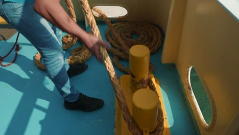 close-up of a man mooring - tying and securing a vessel to the dock with a clove hitch knot greece