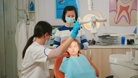 dentistry doctor speaking to kid sitting on stomatological chair