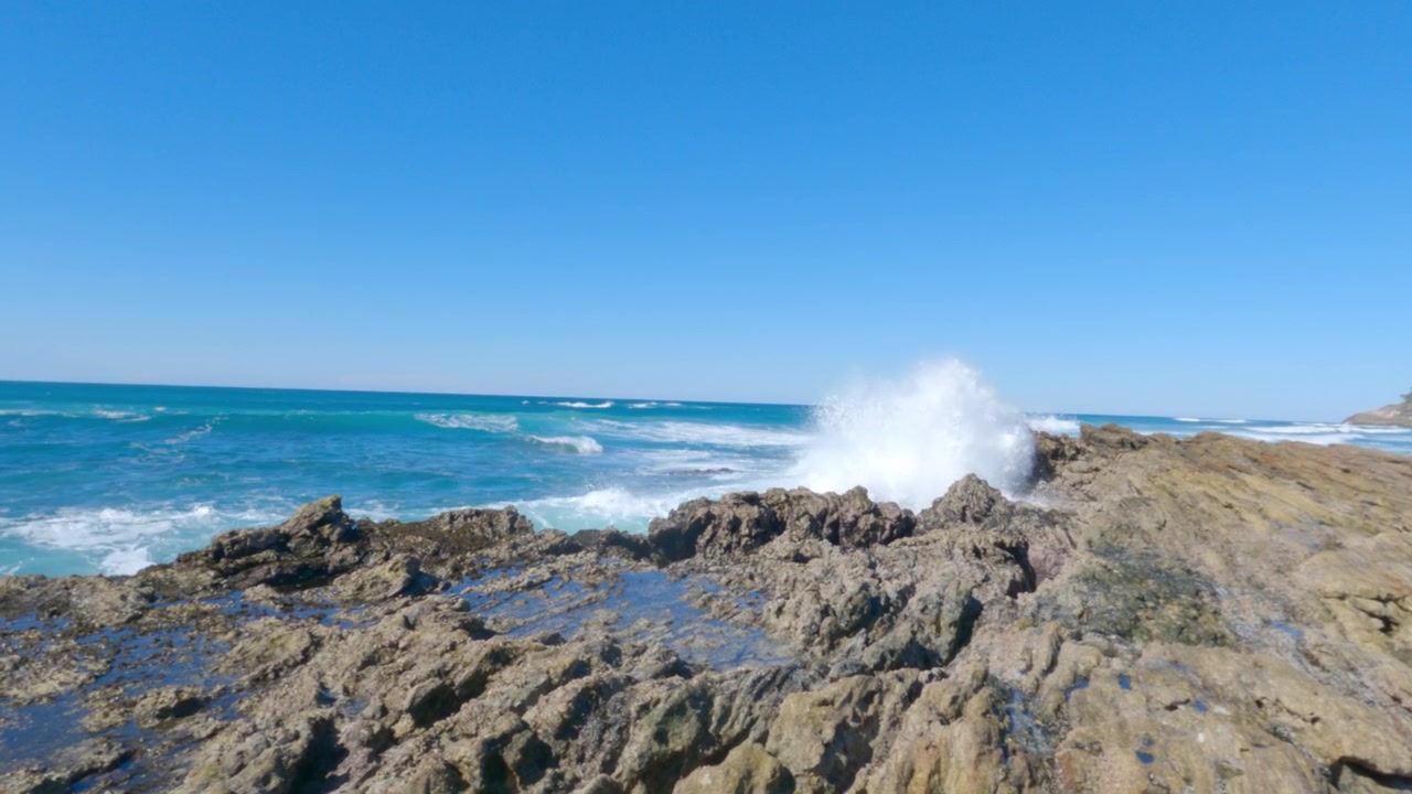 Costa rocciosa dell'isola di Stradbroke con onde oceaniche che si infrangono sulla riva 4K.