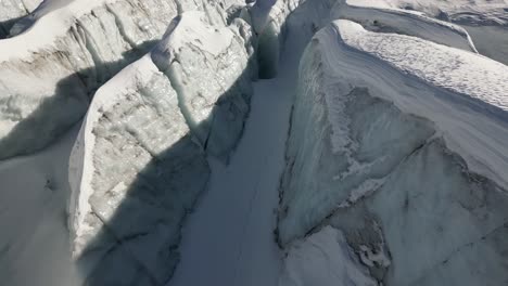 Aerial-push-in:-glacier-and-its-icy-facades-on-a-Swiss-alps-mountain-in-winter