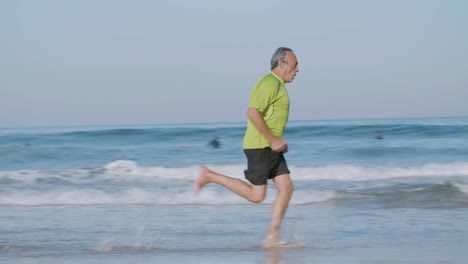 Un-Hombre-Concentrado-Corriendo-A-Un-Ritmo-Rápido-A-Lo-Largo-De-La-Costa-Del-Océano-En-Un-Día-De-Verano