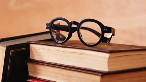 stack of books with spectacles on a desk