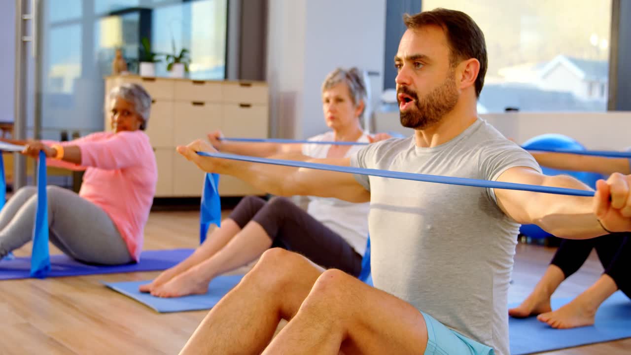 entrenador ayudando a las mujeres mayores en la realización de yoga 4k