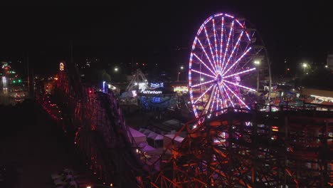 Riesenrad-Und-Achterbahnfahrt-Bei-Nacht