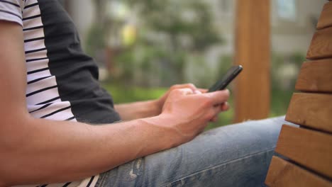 el hombre está escribiendo un mensaje en su teléfono móvil
