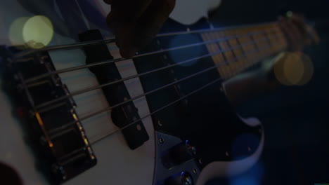 musician plucking bass guitar strings under stage lights, with animated music waveform bars pulsing