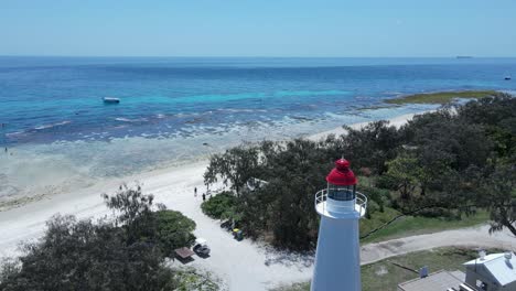 unique lighthouse looking over a tropical reef surrounded by shades of blue water