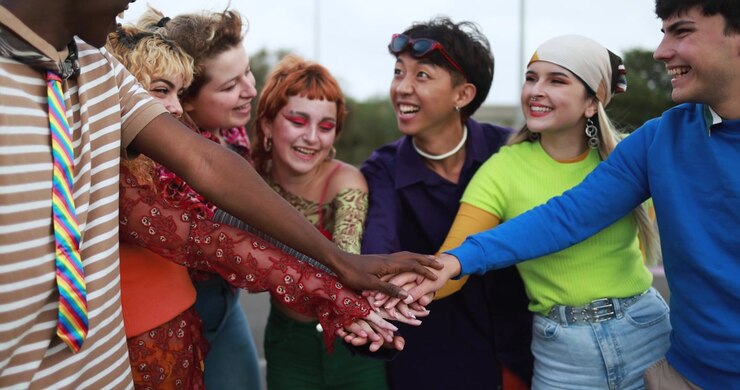 Diverse Young People Smiling and Stacking Hands in a Huddle